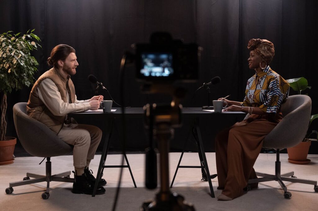 pexels photo 6883810 Two adults engaging in a podcast discussion in a studio with recording equipment.